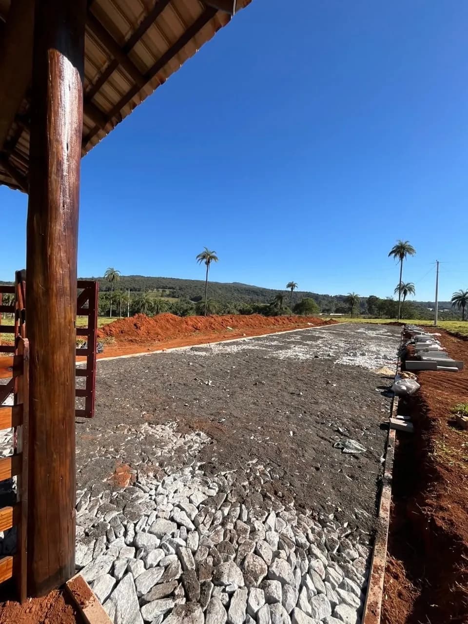 Calçamento de pedra sendo executado no acesso.